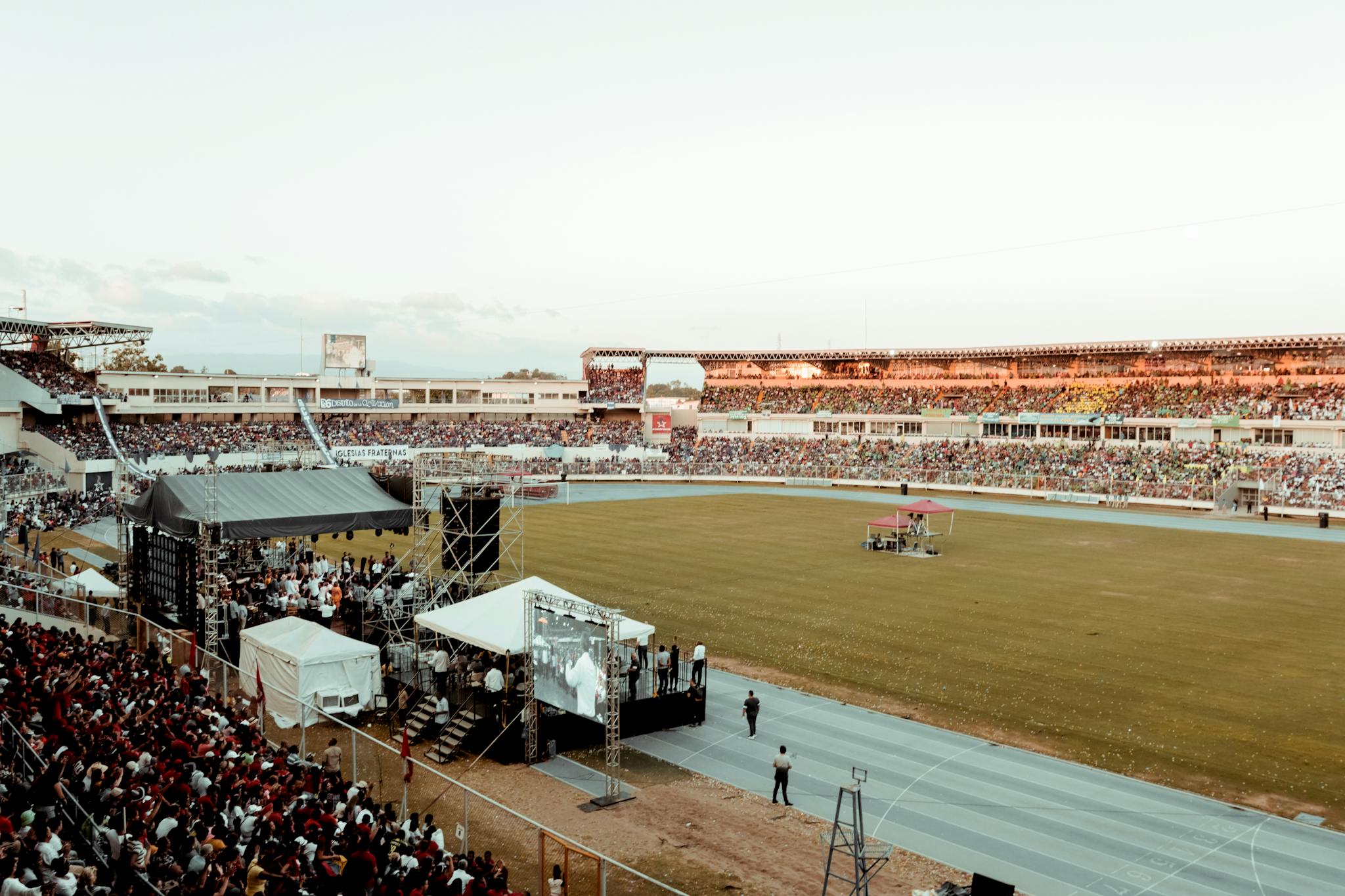 A lively crowd gathers at a football stadium during an outdoor event, showcasing spectator excitement.